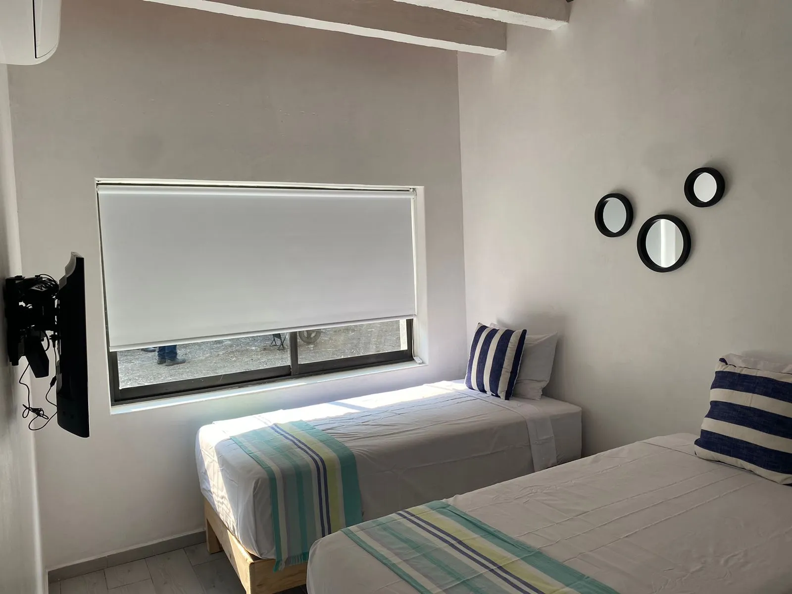 Dos camas individuales con espejos redondos decorativos